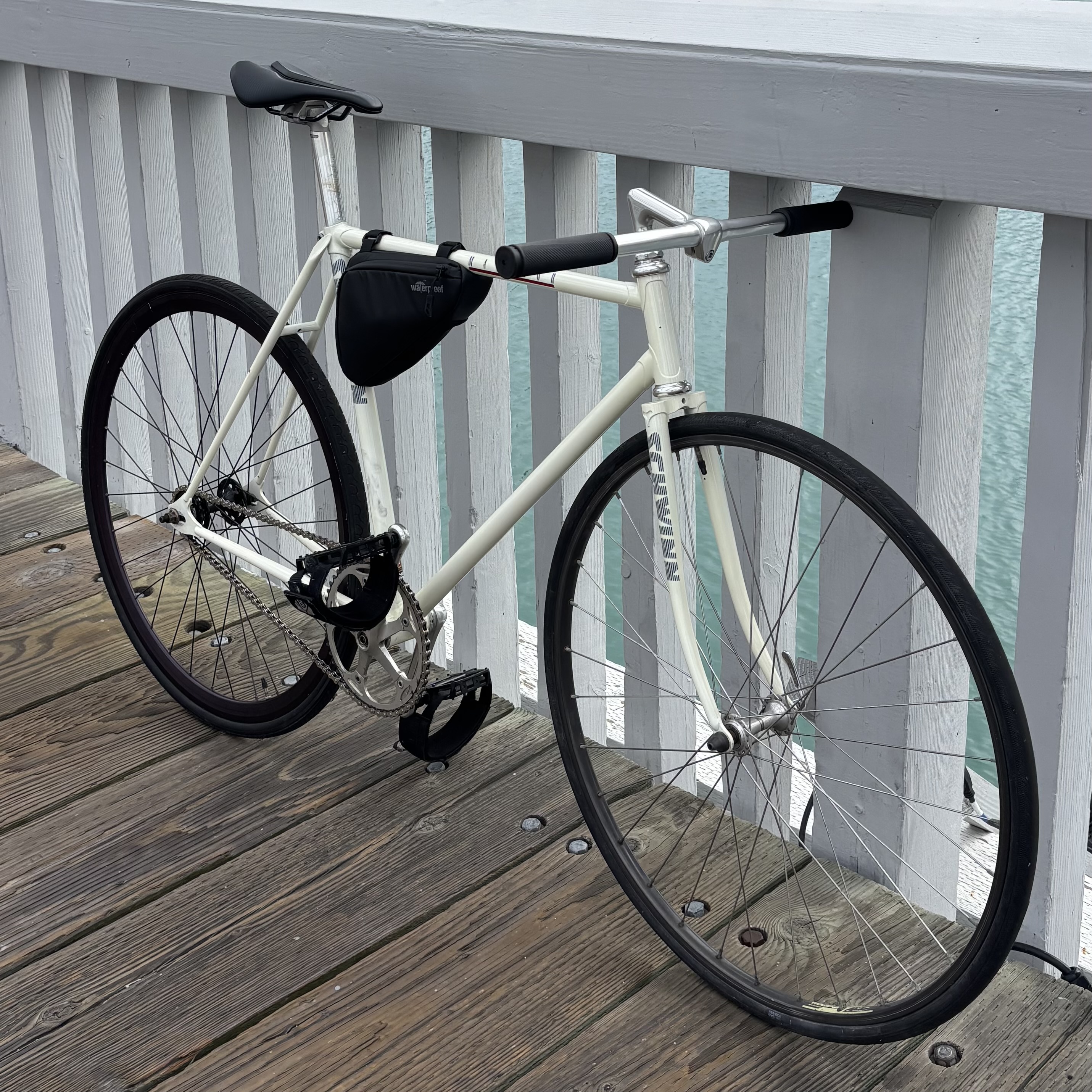 White bicycle beside a waterfront railing
